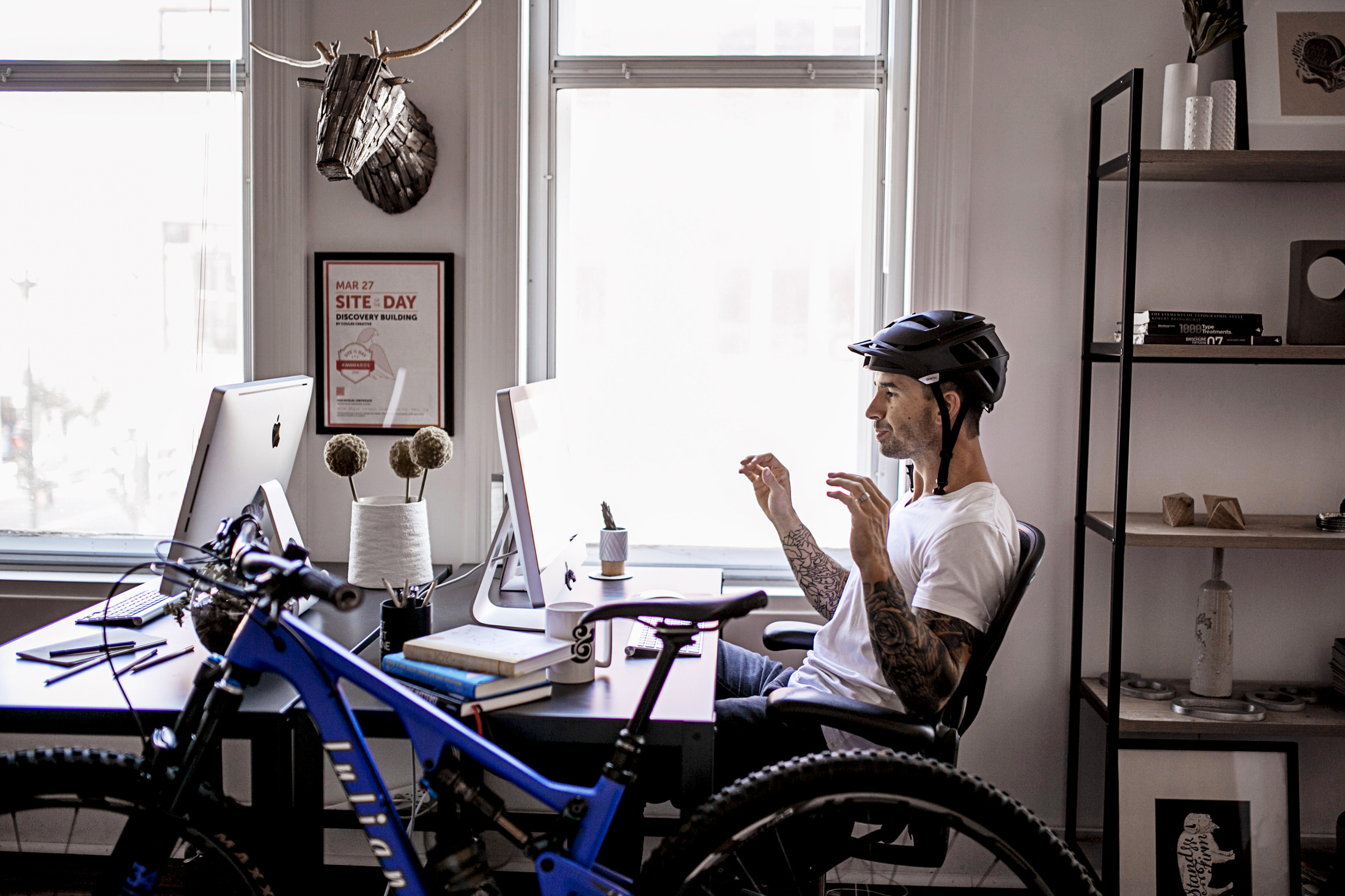working with bike helmet at computer